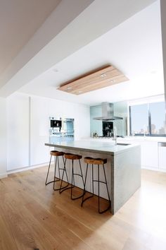 two stools sit at the center of a kitchen island in an open floor plan