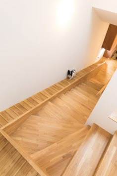 a cat is sitting on the wooden floor in an empty room with white walls and wood floors