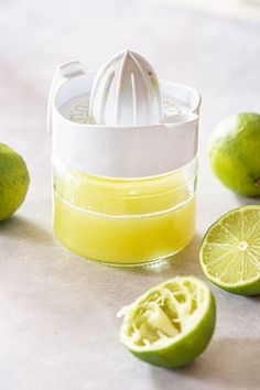 lime juice in a blender next to sliced limes