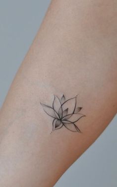 a small black and white flower tattoo on the arm