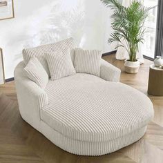 a large white chair sitting on top of a wooden floor