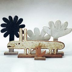 a sculpture of an airplane and flowers on a white surface with a black flower in the background