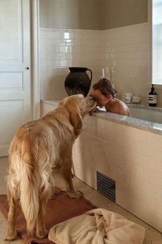 a man and his dog are in the bathroom