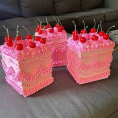 there are three cakes with cherries on the top and one has pink frosting