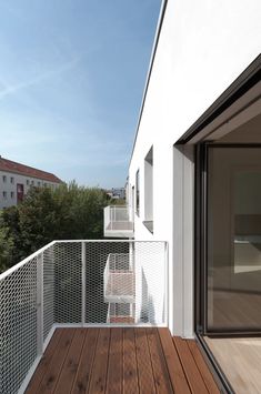 a balcony with wooden floors and white walls