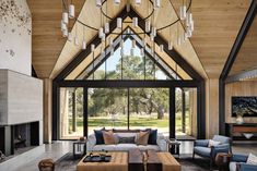 a living room filled with furniture and a large window covered in glass doors that look out onto a lush green field