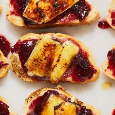 several pastries with jam on them sitting on a white surface