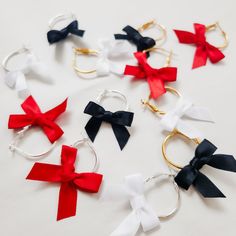 These elegant ribbon bow earrings are perfect for adding a touch of fun to your night. The most adorable bow dangle earrings perfect for the holiday season or a great bridesmaid gift! Available in three colors white, black or red and each bow is handmade with silky soft satin ribbon. Hoops are 14 karat gold plated or sterling silver plated hoop are hypoallergenic and nickel free Hoops are 1 inch in total diameter and 1 1/2 inches in total length with the bow.  Christmas Earrings, Christmas Gift Unique Wedding Veils, Christmas Gift Bow, Halloween Themed Wedding, Mini Bow, Tiny Bow, Bow Christmas, Napkin Design, Handmade Gifts For Her, Mini Bows