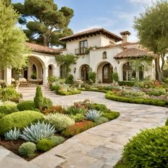 a large house with lots of plants and trees in front of the entrance to it