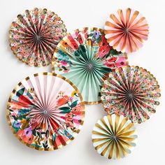 four decorative paper fans on a white surface