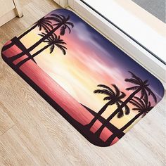 a door mat with two palm trees and the sun setting in the sky behind it