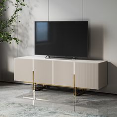 a flat screen tv sitting on top of a white cabinet