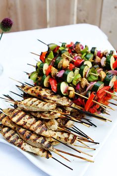 several skewers of food on a white plate