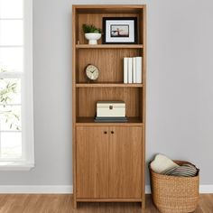 a wooden bookcase with books and pictures on it next to a wicker basket