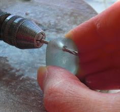 a person holding a screw in their right hand and the other hand is using it