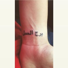 a woman's foot with the word arabic written in black ink on her wrist