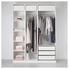 a white closet with clothes hanging on the shelves and other items in front of it