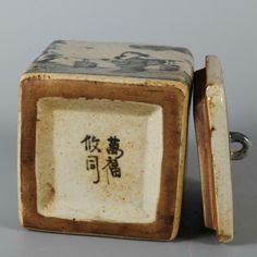 an old porcelain box with chinese writing on it