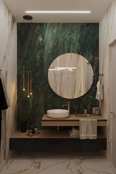 a bathroom with marble walls and a round mirror on the wall, along with a sink