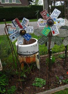 a bunch of street signs that are in the grass and some plants with flowers growing out of them