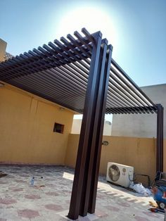 the sun is shining on an outdoor patio with a pergolated covering over it