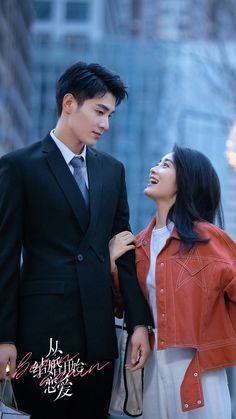 a young man and woman walking together in the city, one holding her hand on his shoulder