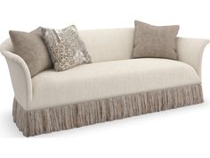 a couch with two pillows on it and fringe trimming around the armrests