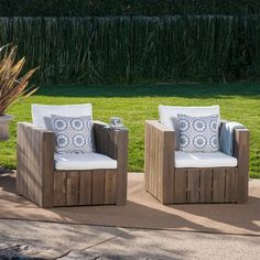 two wooden chairs sitting next to each other on a patio