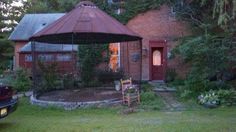 a car parked in front of a house with a gazebo on it's roof