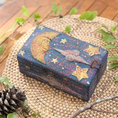 an old wooden box sitting on top of a table next to a pine cone