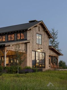 a large wooden house sitting on top of a lush green field