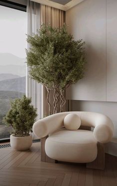 a white chair sitting next to a potted plant in front of a large window