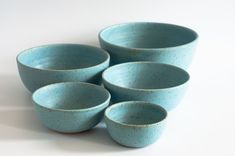 five blue bowls are stacked on top of each other