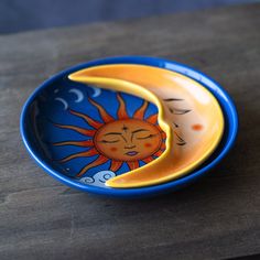 a blue bowl with a sun and moon painted on it