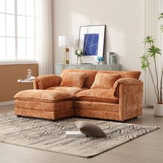 a living room with a sectional couch and rug in front of the window on the floor