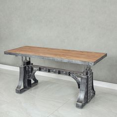 a wooden table sitting on top of a white floor next to a gray and grey wall