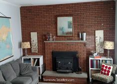 a living room with a couch, chair and fire place in front of a brick wall