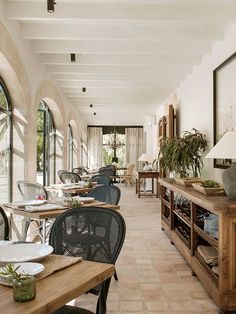 an empty restaurant with tables and chairs on the sidelines, windows to the outside