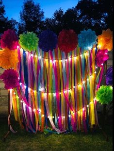 colorful streamers and lights are hanging on the wall in front of a building at night