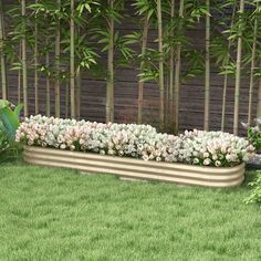 a garden filled with lush green grass and lots of flowers next to a tall bamboo tree