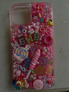 a cell phone case with lots of different things on the front and back cover in pink