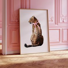 a framed photograph of a leopard sitting on the floor