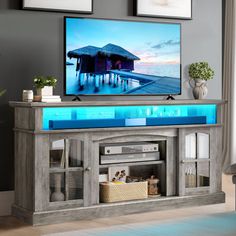 a flat screen tv sitting on top of a wooden entertainment center in a living room