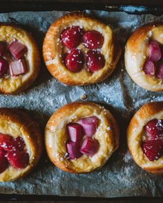 small pastries with strawberries and jelly in them on a baking sheet, ready to be eaten