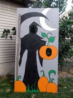 a painted cornhole with an image of a witch and pumpkins