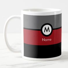 a black, red and gray striped mug with the letter m on it