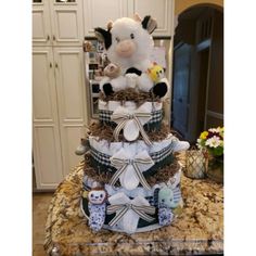 a large stuffed animal sitting on top of a tiered cake covered in diapers