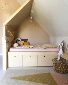 an attic bedroom with a bed, dresser and toy chest under the slanted roof