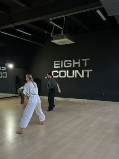 two people standing in an empty room with the words eight count written on the wall