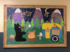 a bulletin board with an image of a bear and campfire